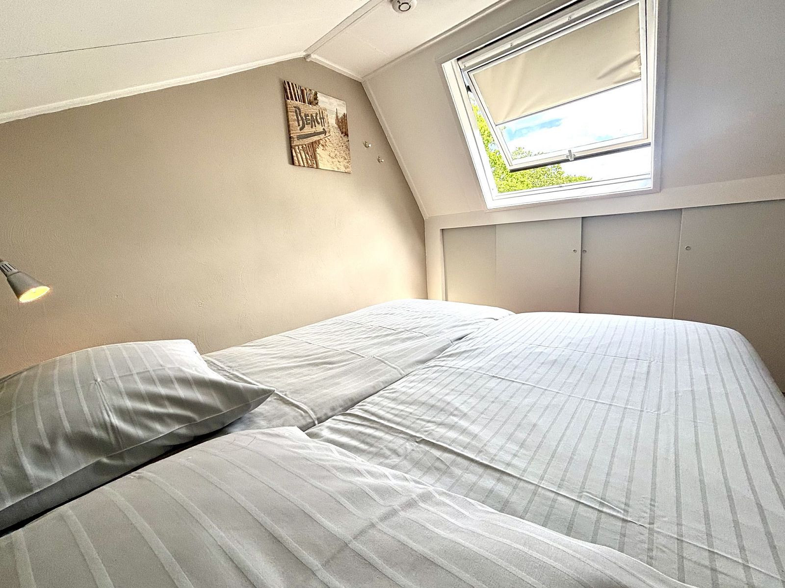 Ruime slaapkamer in Appartement Boszicht 3, Oostkapelle, Walcheren, Zeeland met veel natuurlijk licht.