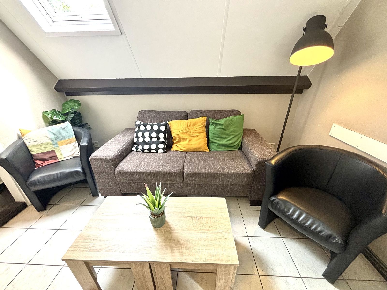 Zithoek in Appartement Boszicht 3, Oostkapelle, Walcheren, Zeeland met kleurrijke kussens en veel comfort.