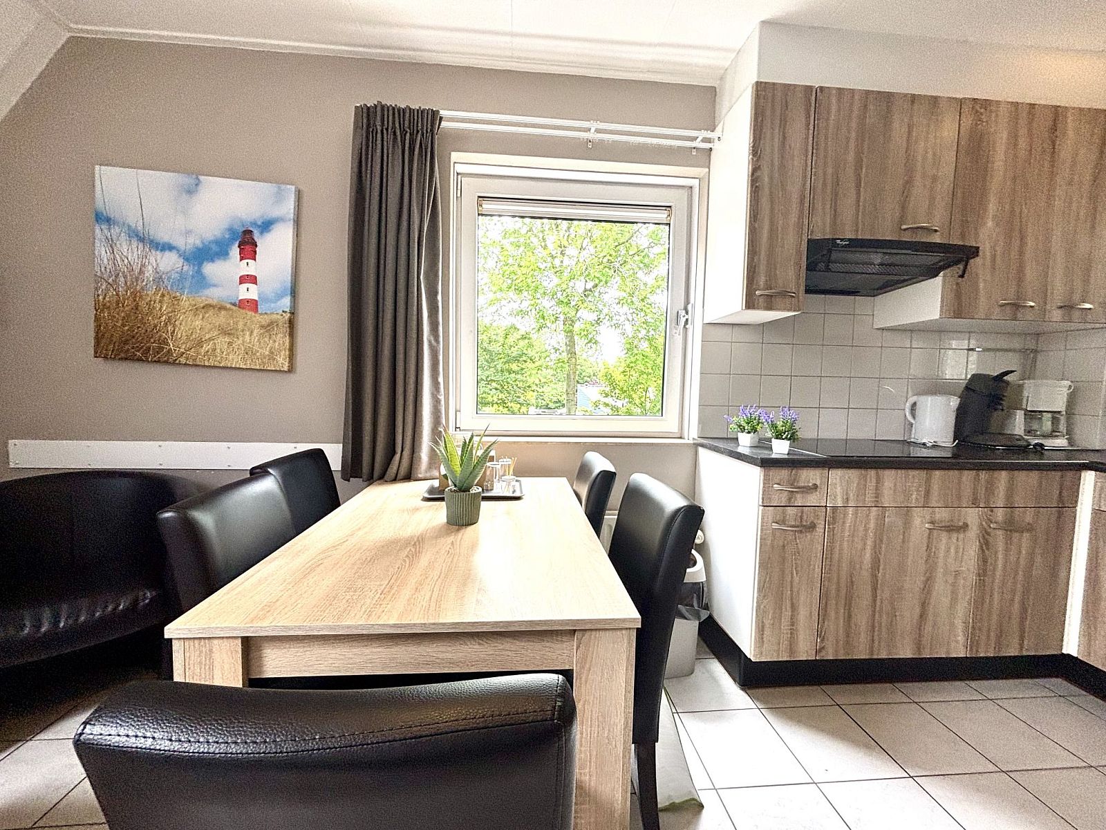 Eethoek in Appartement Boszicht 3, Oostkapelle, Walcheren, Zeeland met uitzicht op de groene omgeving.