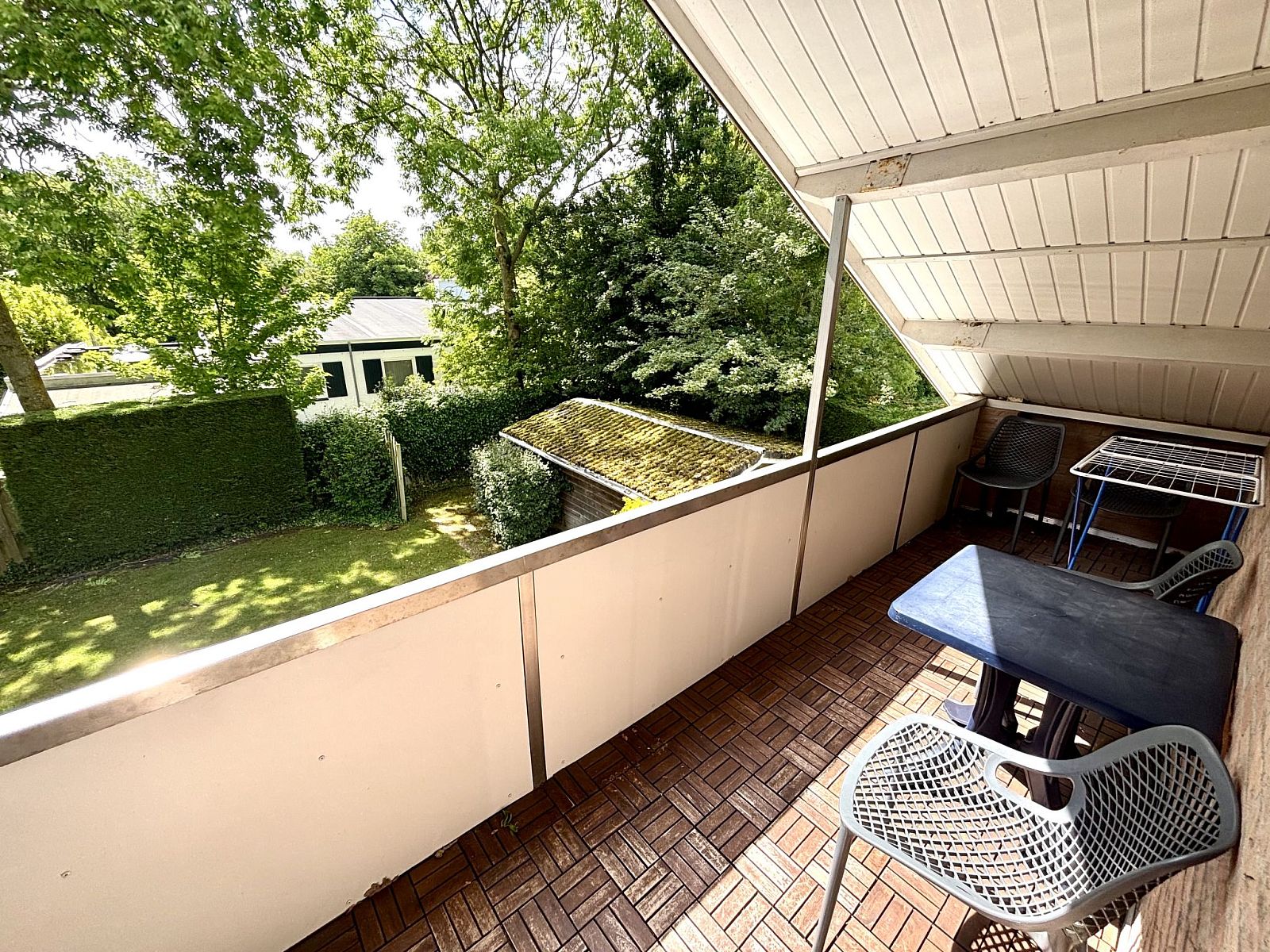 Balkon van Appartement Boszicht 4 in Oostkapelle, Walcheren, Zeeland met uitzicht op groene tuin.