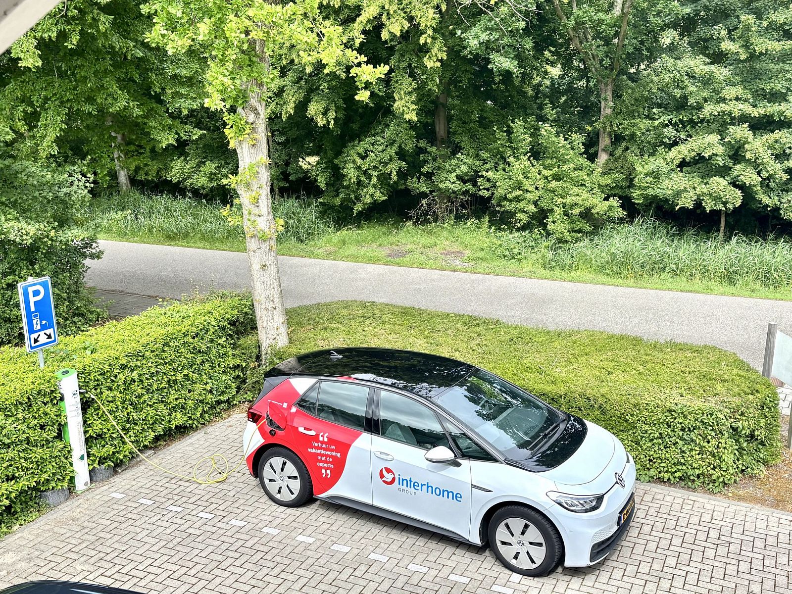 Parkeerplaats met elektrische auto bij Appartement Boszicht 4, Oostkapelle, Walcheren, Zeeland.