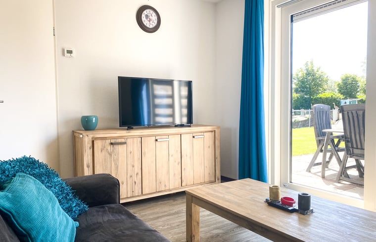 Lichte woonkamer van Vakantiehuisje in Oostkapelle met toegang tot het terras in Walcheren, Zeeland.