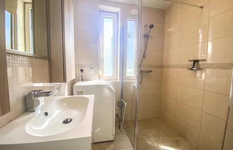 Moderne badkamer in Vakantiehuisje in Oostkapelle, Walcheren, met douche en wasmachine.