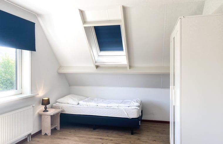 Slaapkamer met eenpersoonsbed in Vakantiehuisje in Oostkapelle, Walcheren, met dakraam.