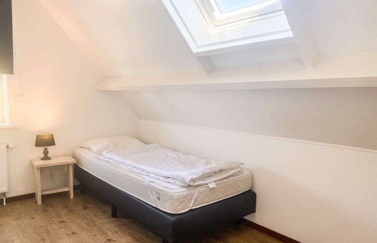 Lichte slaapkamer met eenpersoonsbed in Vakantiehuisje in Oostkapelle, Walcheren, Zeeland.