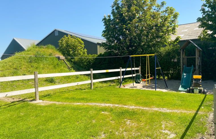 Speeltuin in de tuin van Vakantiehuisje in Oostkapelle, Walcheren, met schommel en glijbaan.