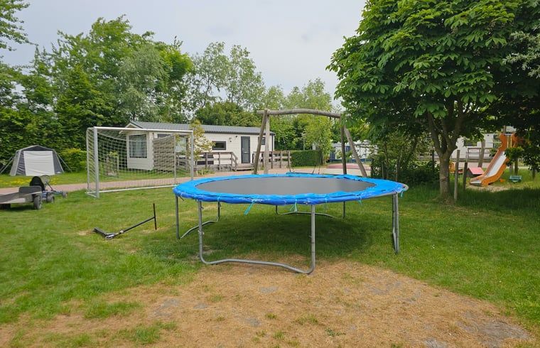 Spielplatz am Ferienhaus in Oostkapelle, Ferienhaus in Walcheren, Zeeland mit Trampolin und Spielgeraeten fuer Kinder.