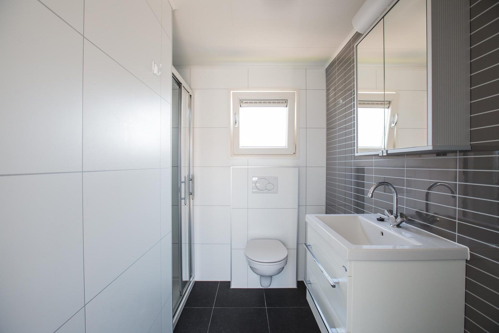 Elegantes Badezimmer in VZ983 Ferienhaus Oostkapelle, Walcheren, mit Dusche und Waschbecken.