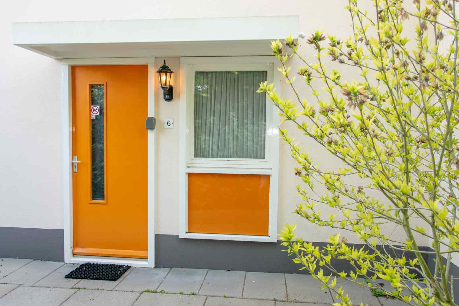 Haustuer des Ferienhauses ZE1402 in Oostkapelle, Walcheren, Zeeland mit auffallend oranger Farbe.