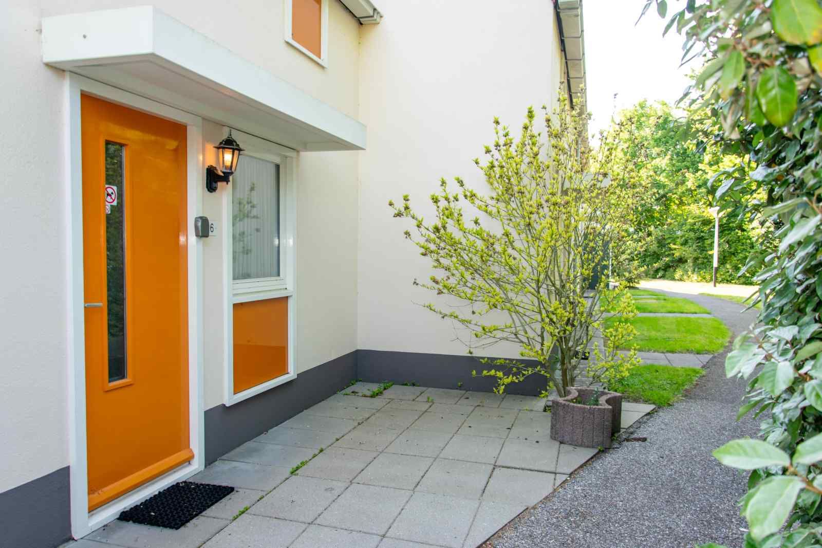 Eingang zum Ferienhaus ZE1402 in Oostkapelle, Walcheren, Zeeland mit gruener Umgebung.