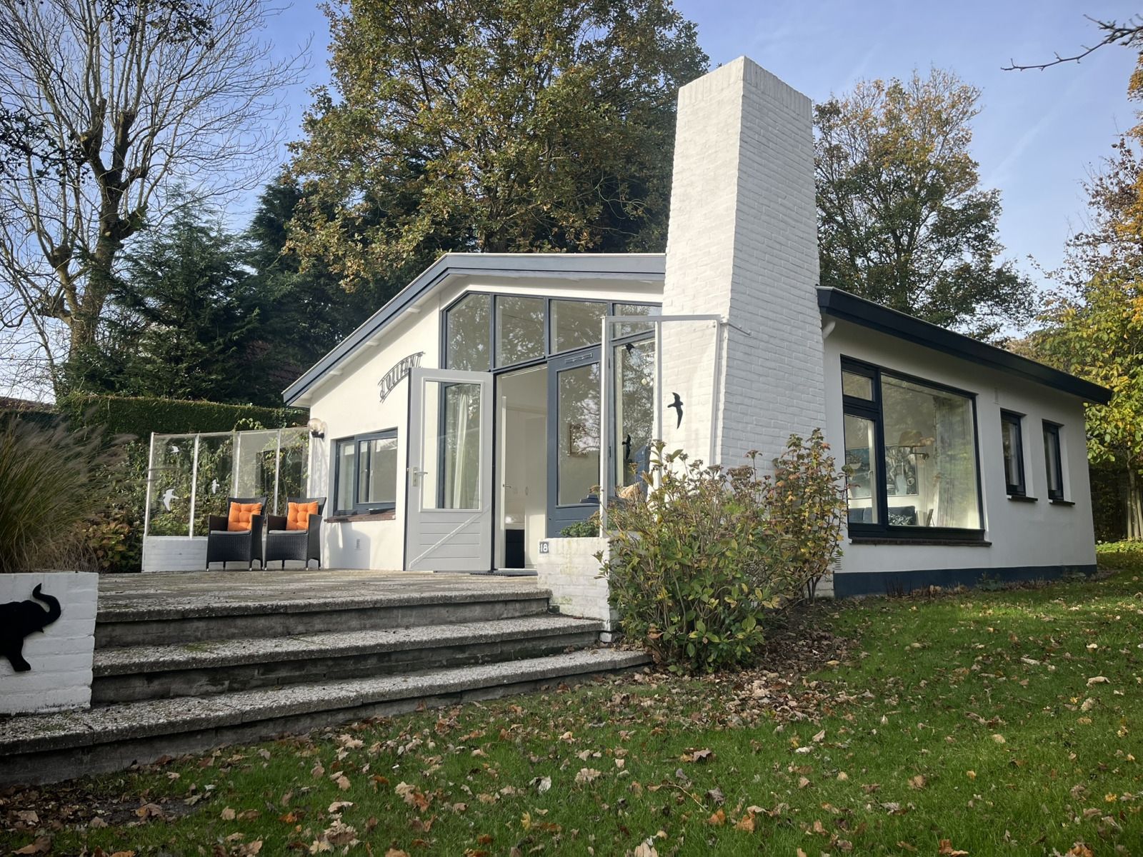 Geniet van de zonnige veranda van vakantiehuis ZE1678 in Oostkapelle, Walcheren, Zeeland, met comfortabele zitplaatsen en groene omgeving.