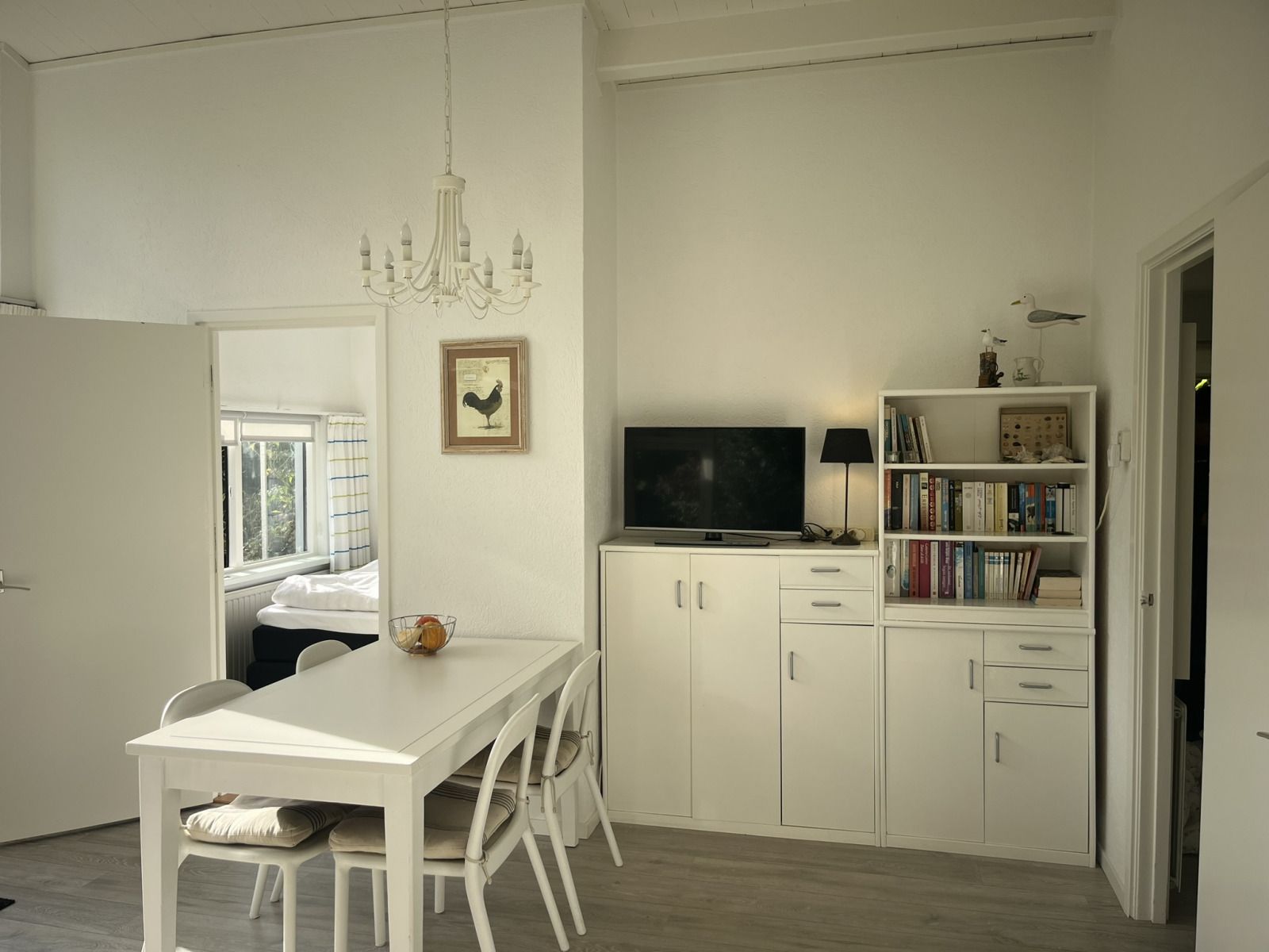 Gezellige zithoek in vakantiehuis ZE1678, Oostkapelle, Walcheren, met kunst aan de muur en uitzicht op de tuin in Zeeland.