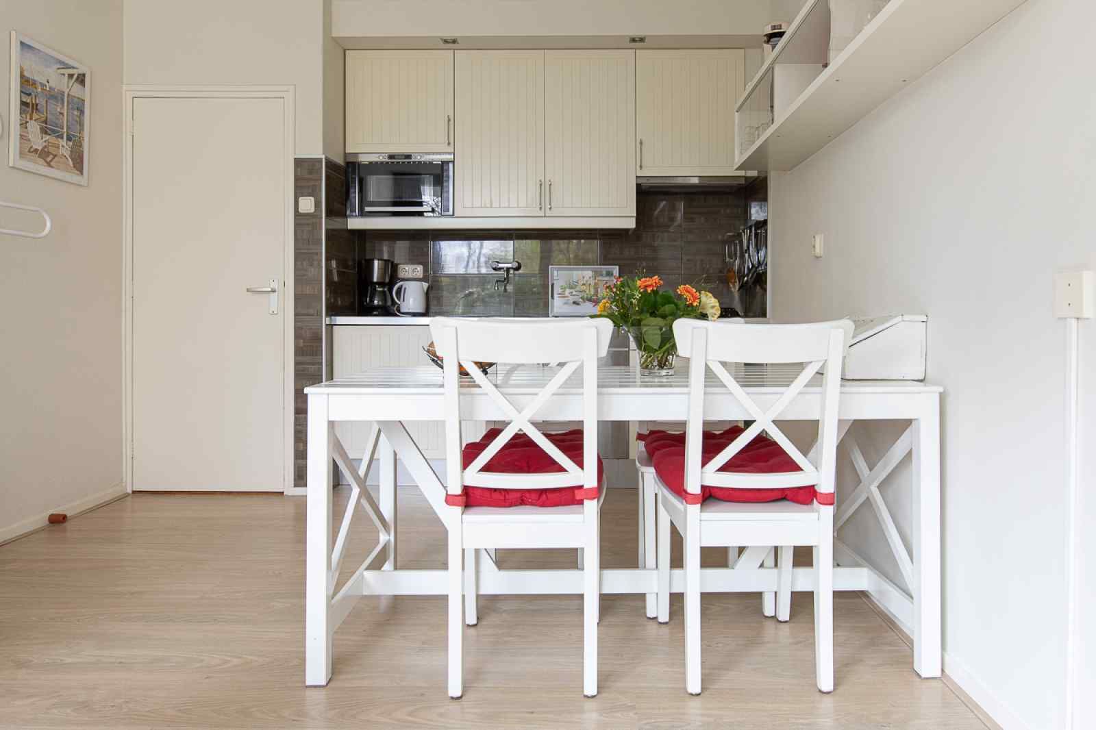 Esszimmer und Kueche im Ferienhaus ZE069 in Oostkapelle, Walcheren mit frischem, modernem Stil.