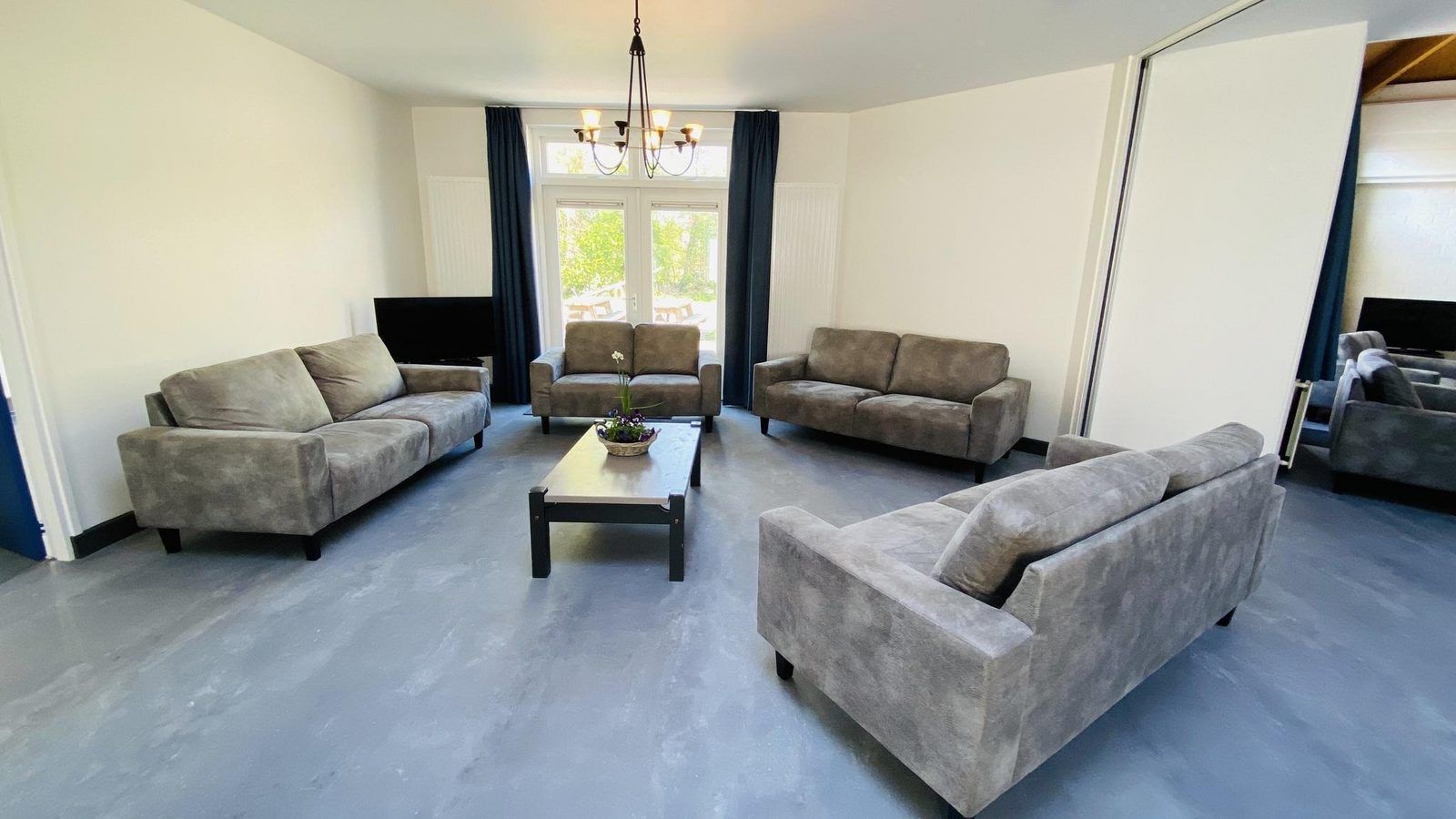 Cozy living room in VZ131 Group accommodation Westkapelle, vacation home in Zeeland with comfortable sofas.