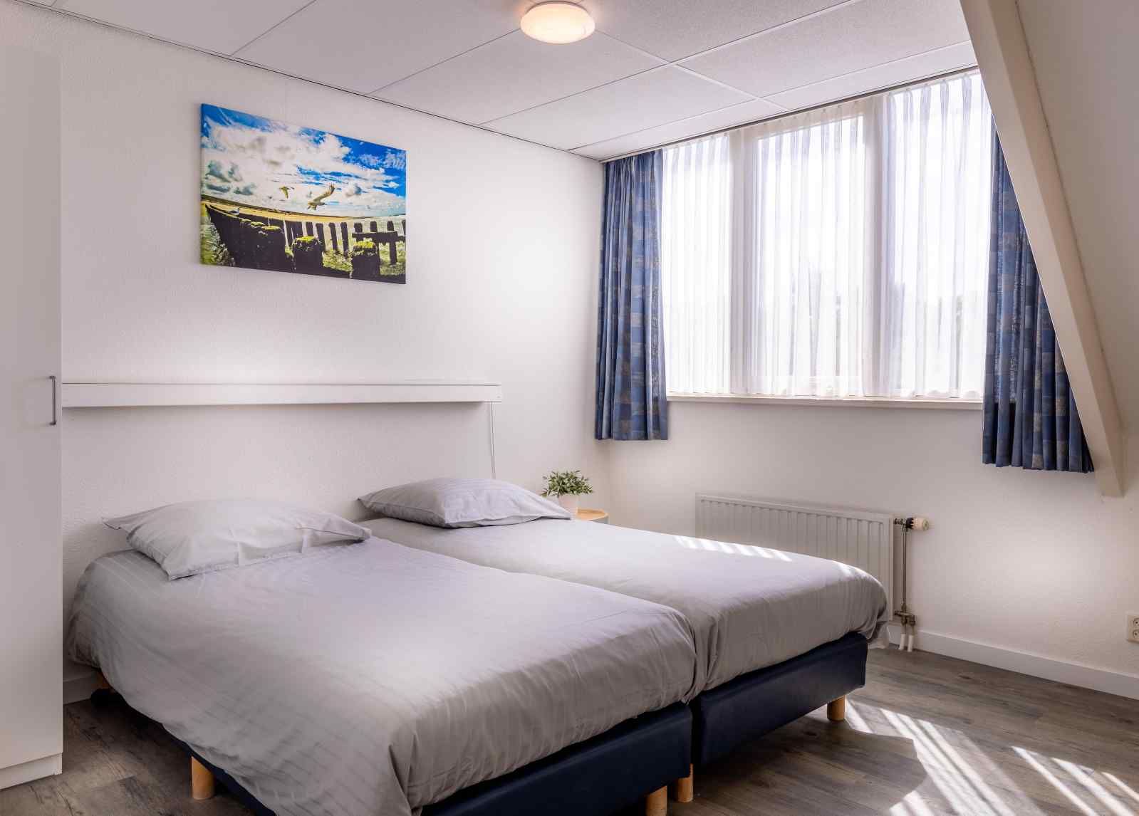 Ruime slaapkamer in vakantiehuis ZE014, Domburg, Walcheren, met comfortabel tweepersoonsbed voor een goede nachtrust.