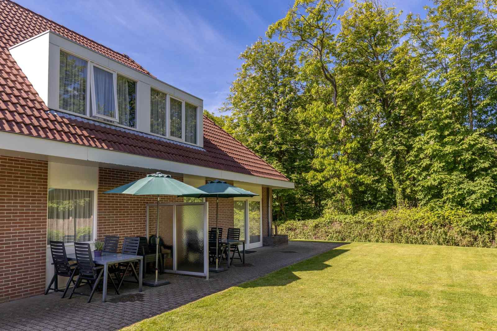 Ingang van vakantiehuis ZE014 in Domburg, Walcheren, met ruime oprit en groene omgeving voor een warm welkom.