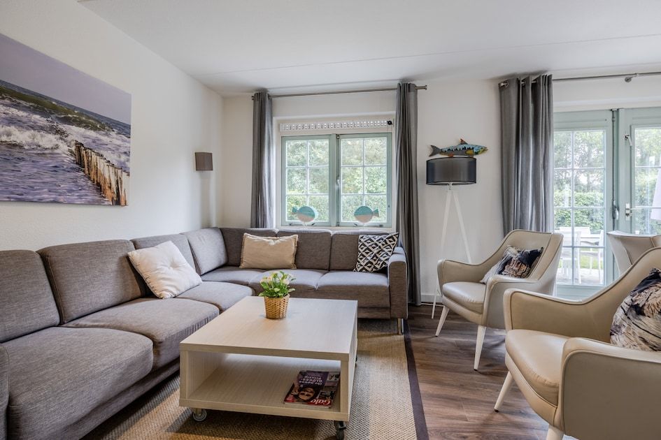 Gemuetliches Wohnzimmer des MK7 Comfort Bungalows in Domburg, Walcheren, Zeeland mit bequemer Sitzecke und Gartenblick.