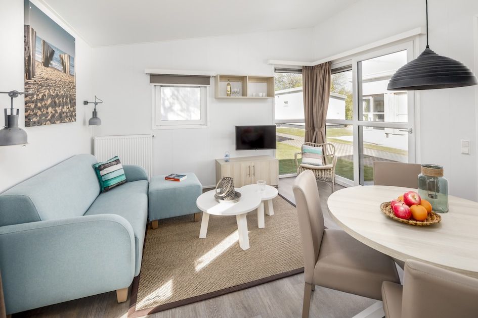 Gezellige woonkamer in L4A Comfort vakantiehuis Domburg, Walcheren, Zeeland met licht interieur en comfortabele zitruimte.