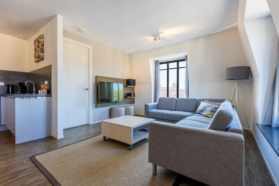 Cozy living room in Bordeaux Comfort 4 apartment, Domburg, Walcheren, with modern decor and city views.