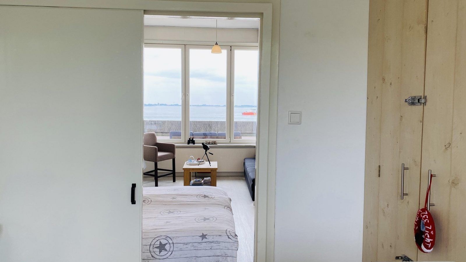 Doorkijk naar de woonkamer van VZ733 Studio Vlissingen, vakantiewoning in Walcheren, met zeezicht.