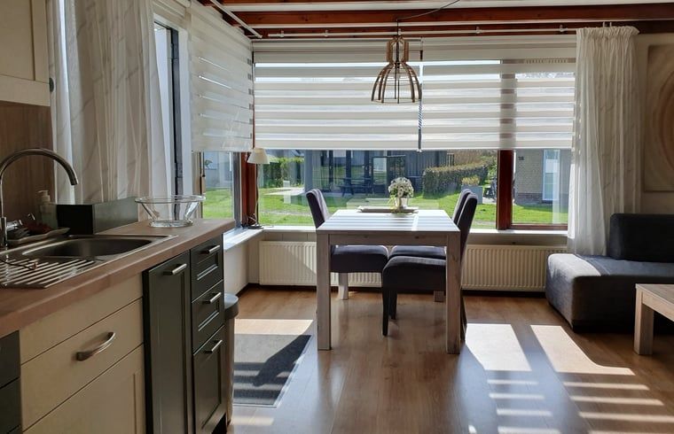 Lichte eetruimte in Vakantiehuisje in Vlissingen met uitzicht op de tuin, ideaal voor een vakantie in Zeeland.