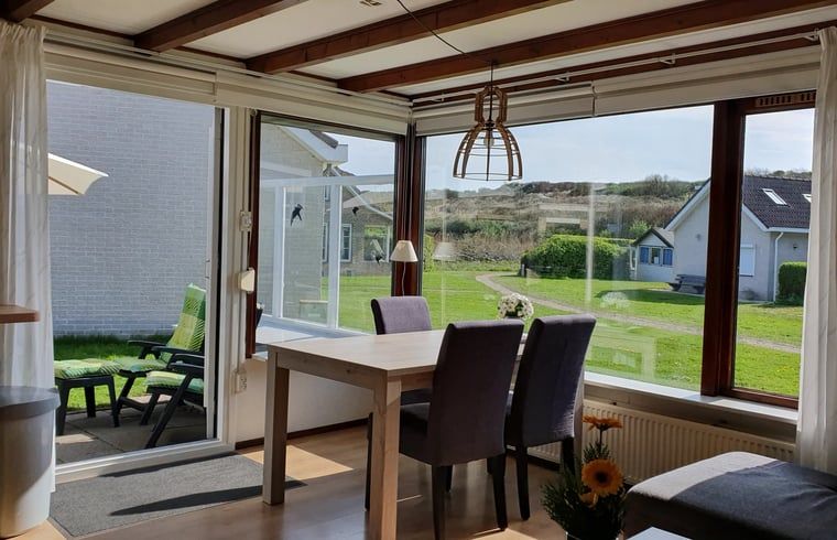Eetkamer met uitzicht op de tuin in Vakantiehuisje in Vlissingen, perfect voor een gezellige vakantie in Zeeland.