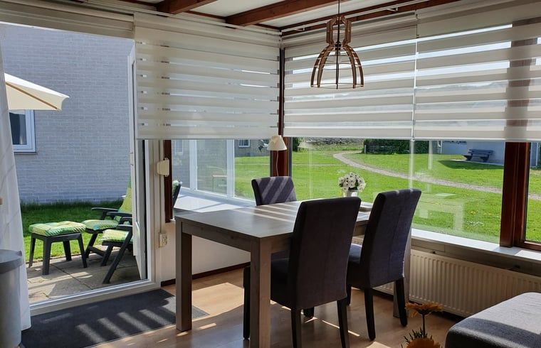 Eetkamer met veel natuurlijk licht in Vakantiehuisje in Vlissingen, ideaal voor een vakantie in Zeeland.