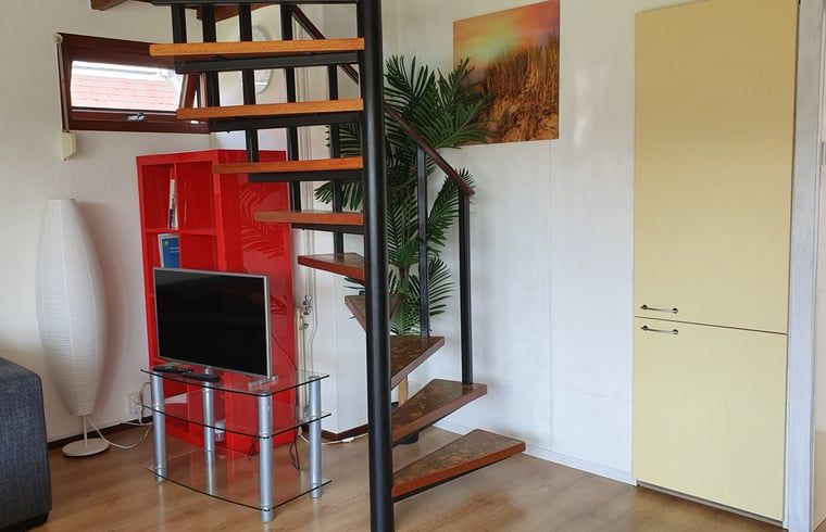 Stijlvolle woonkamer met trap in Vakantiehuisje in Vlissingen, Walcheren, ideaal voor een vakantie in Zeeland.