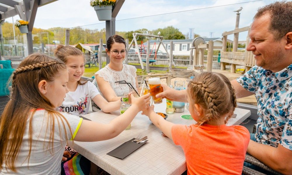 Familie geniesst Mahlzeit in der Naehe von Zeeotter 6 Person chalet, Zoutelande, Walcheren, Zeeland.