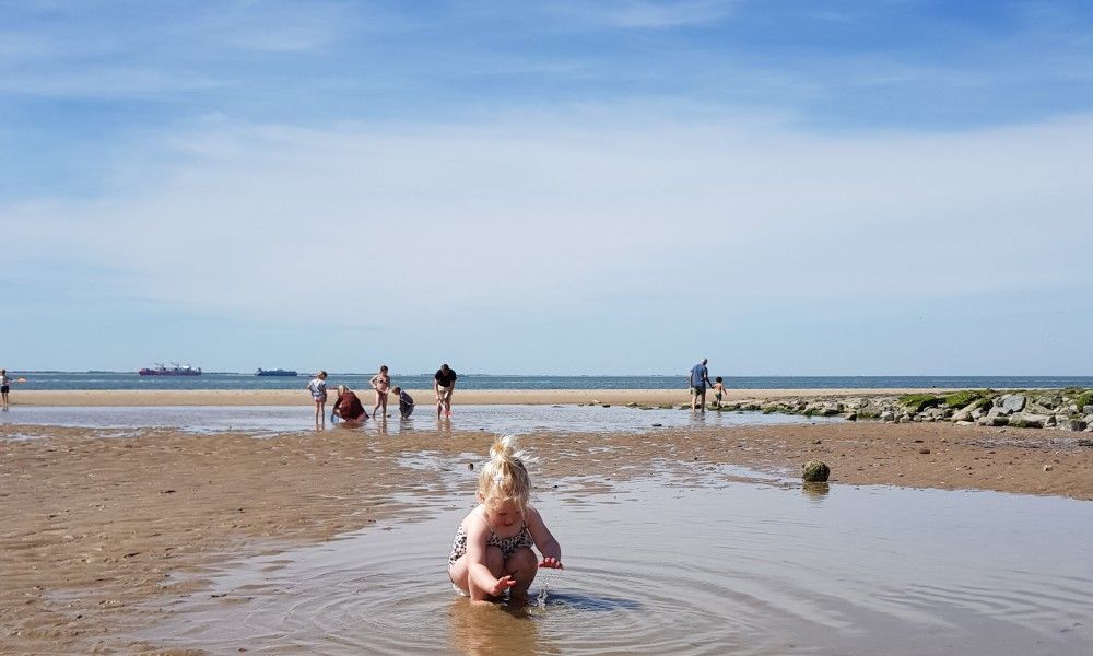 Kinder spielen am Strand von Zoutelande, in der Naehe des Chalets Zeeotter 6 Persoons, Walcheren, Zeeland.