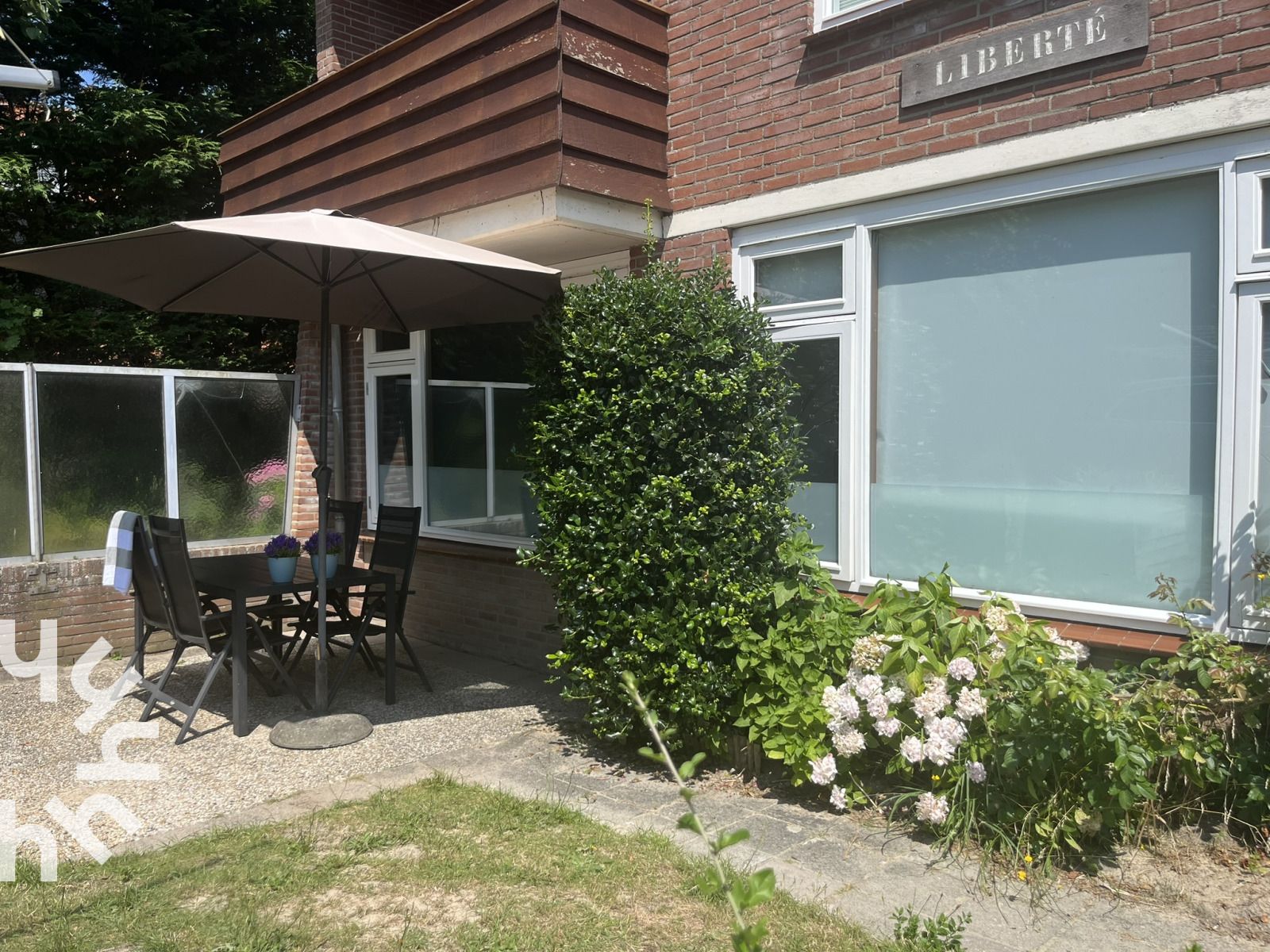 Gezellig terras bij vakantiehuis ZE301 in Zoutelande, Walcheren, met parasol en tuinmeubilair.