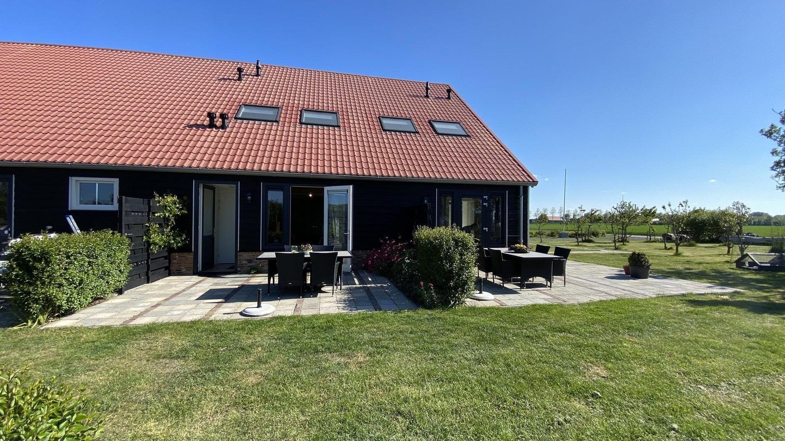 Die sonnige Terrasse von VZ587 Ferienhaus Vrouwenpolder, Walcheren, ist ideal fuer Mahlzeiten im Freien.