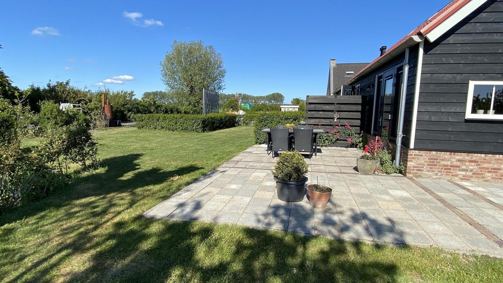 Gruene Umgebung und Terrasse von VZ587 Vakantiewoning Vrouwenpolder in Zeeland.