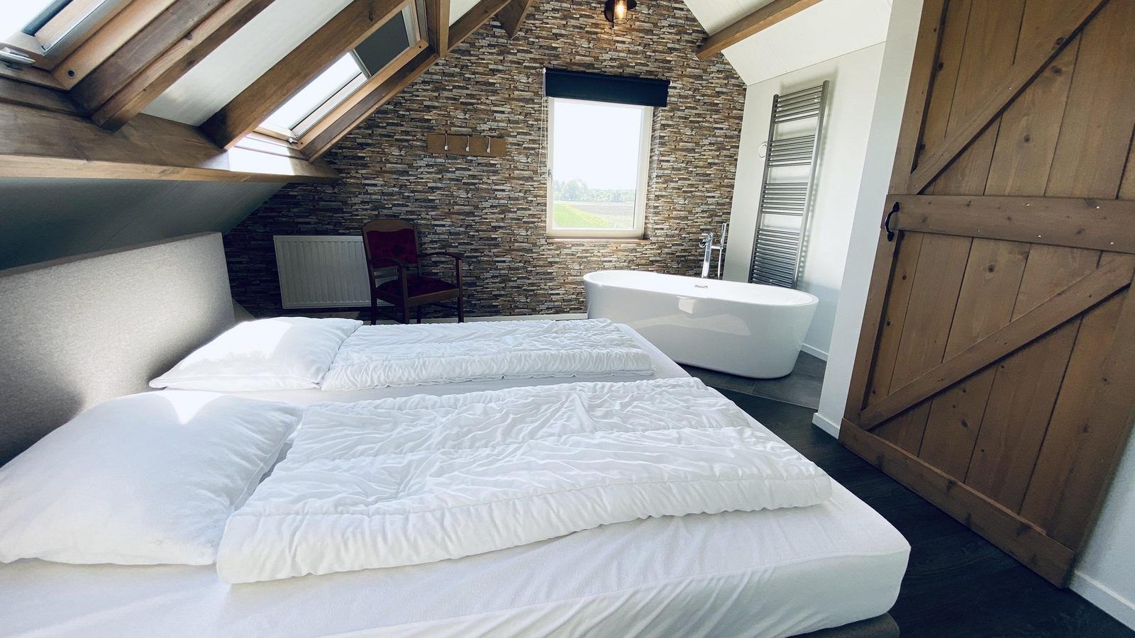 Schlafzimmer mit freistehendem Bad in VZ587 Ferienhaus Vrouwenpolder, Zeeland.