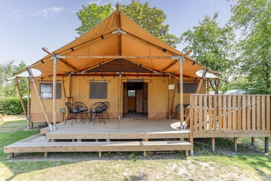 Das Safari-Zelt 8 in Vrouwenpolder, Walcheren, bietet eine charmante Glamping-Unterkunft mit einer einladenden Terrasse und einer natuerlichen Umgebung.
