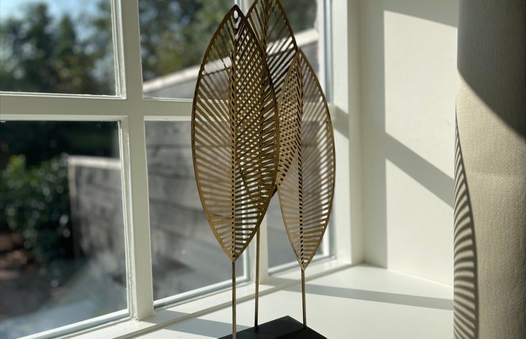 Stijlvolle decoratie bij het raam in Huisje in Veere, vakantiehuis in Walcheren, Zeeland met natuurlijk licht.