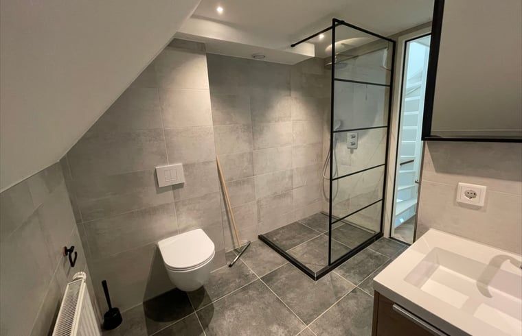 Ruime badkamer in Huisje in Veere, vakantiehuis in Walcheren, Zeeland met inloopdouche en toilet.