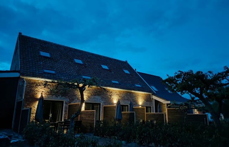 Huisje in Veere, vakantiehuis in Walcheren, Zeeland bij nacht met sfeervolle buitenverlichting.