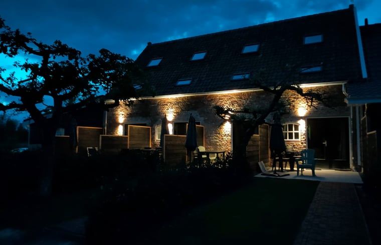 Nachtelijke sfeer bij Huisje in Veere, vakantiehuis in Walcheren, Zeeland met verlichte tuin en terras.