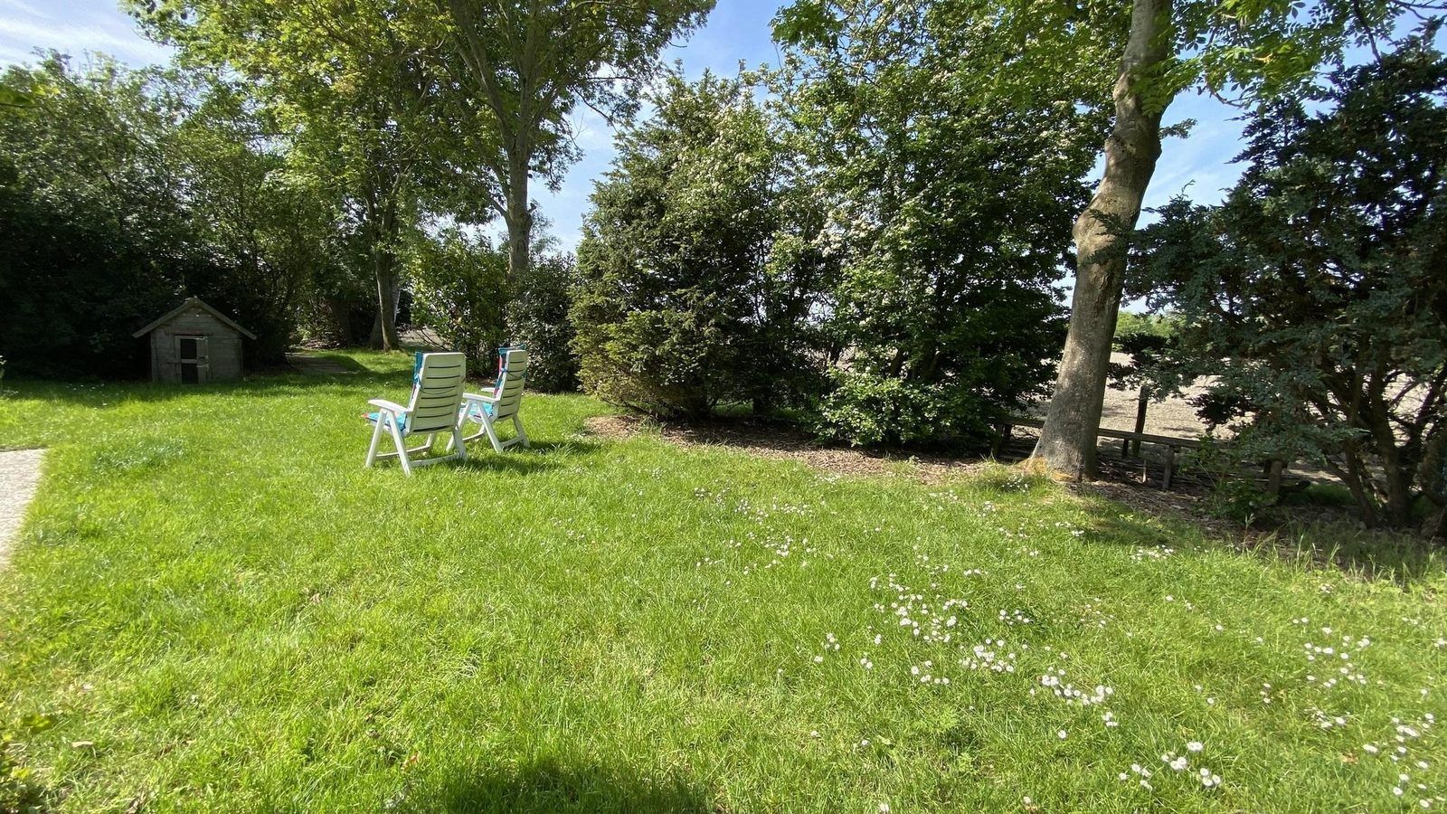 Rustige tuin bij VZ119 Vakantiewoning Veere, omgeven door natuur in Walcheren, Zeeland.