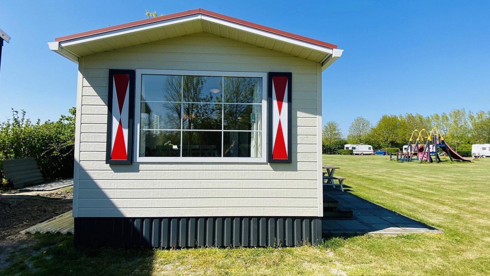 Side view of VZ235 Chalet Veere in Veere, Zeeland with playground nearby