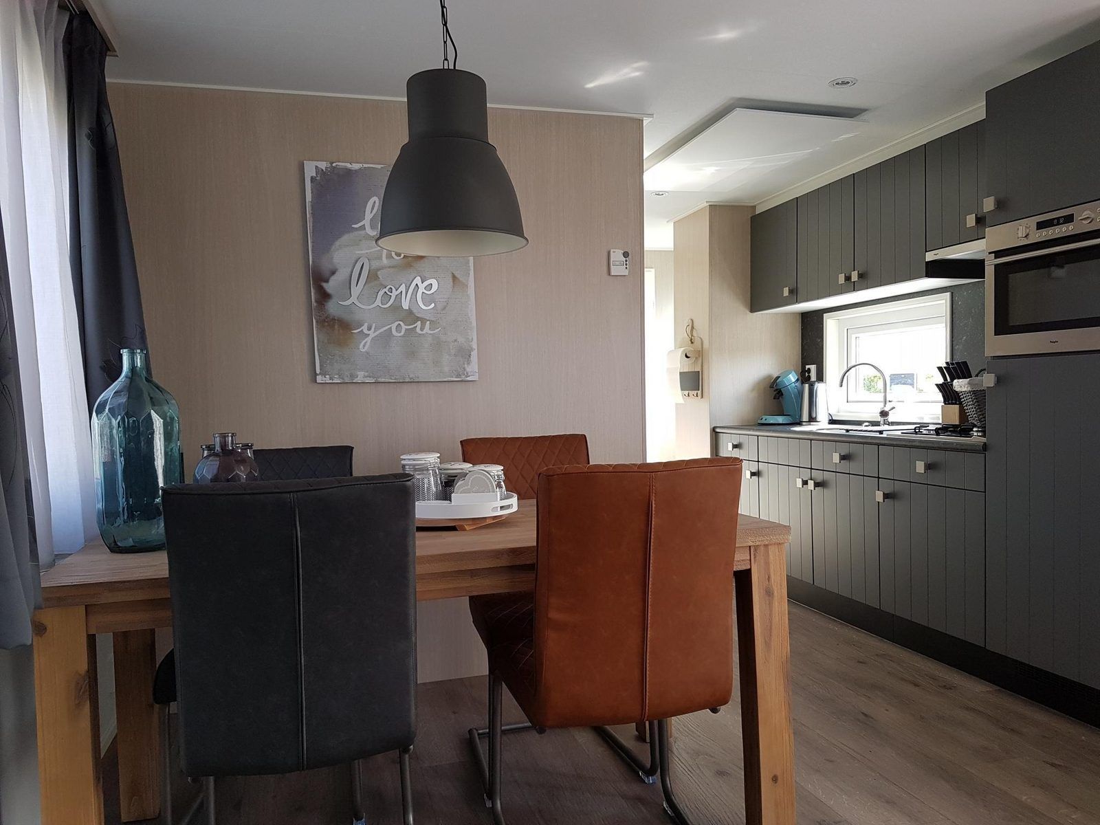 Essecke und Kueche von VZ816 Chalet in Veere, Serooskerke, Walcheren, mit Esstisch aus Holz.