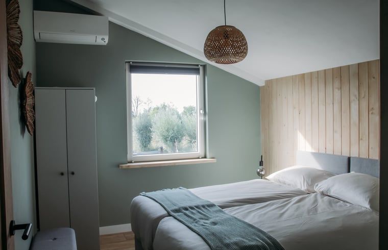 Gezellige slaapkamer met uitzicht op de natuur in Vakantiehuis in Ritthem, Zeeland.