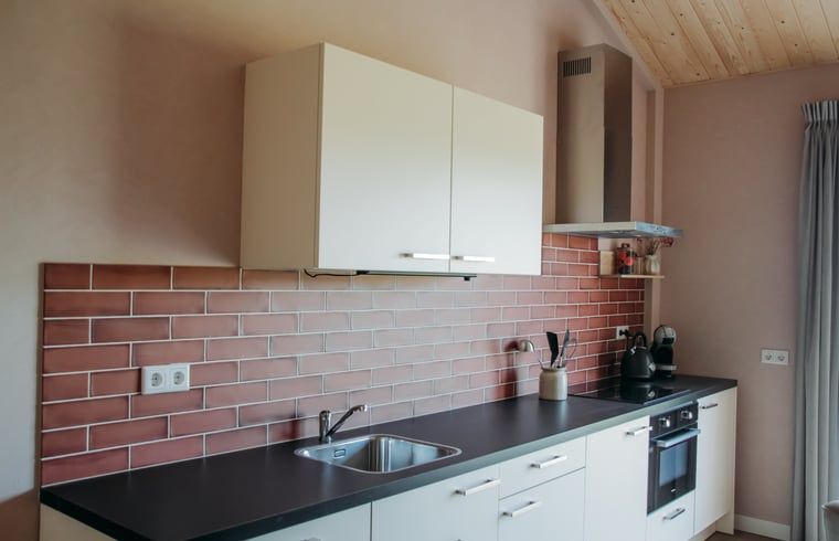 Stijlvolle keuken met rode tegels in Vakantiehuis in Ritthem, Walcheren, Zeeland.