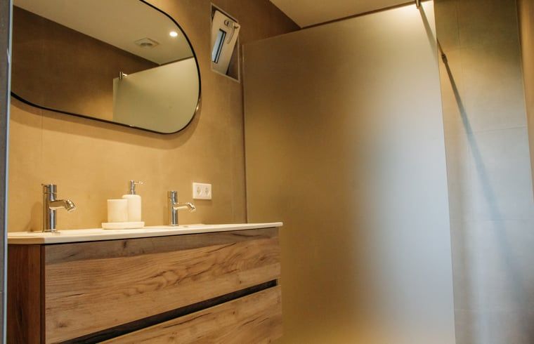 Luxe badkamer met dubbele wastafel in Vakantiehuis in Ritthem, Zeeland.