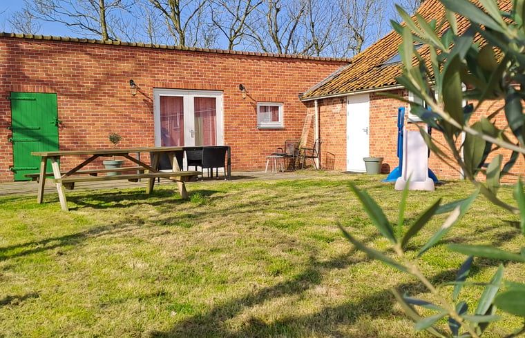 Veranda met picknicktafel en groen uitzicht bij Vakantiehuis in Grijpskerke, Walcheren, Zeeland.