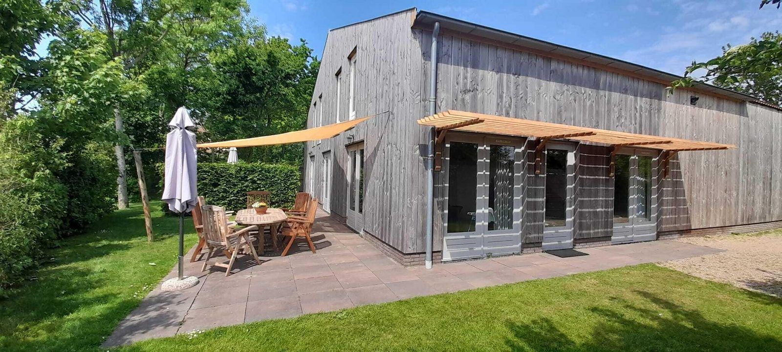 VZ629 Vakantieappartement Grijpskerke, terras met houten stoelen in de natuur van Walcheren, Zeeland.