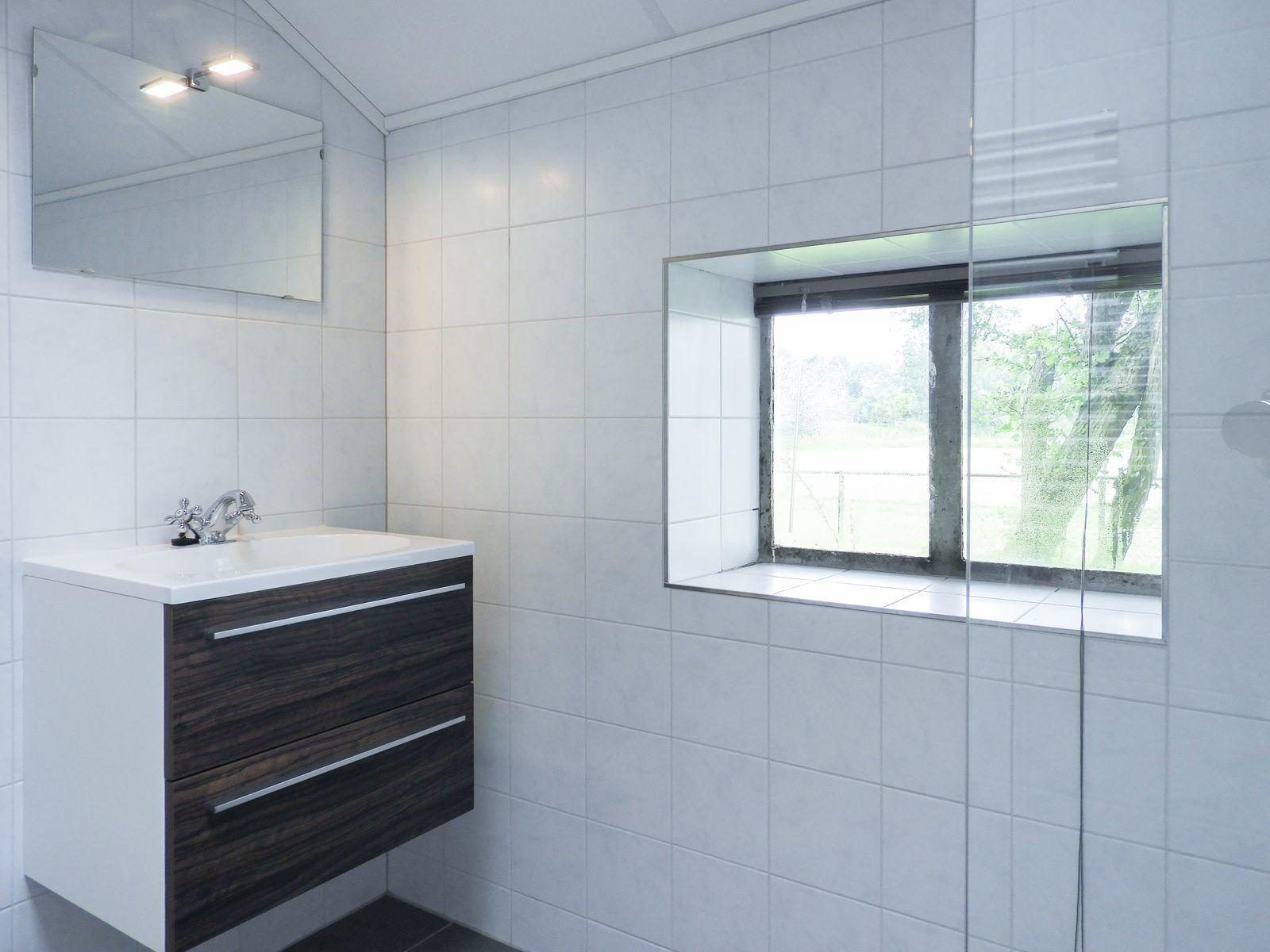 Waschbecken und Spiegel im Badezimmer von VZ494 Ferienhaus Grijpskerke, Walcheren, Zeeland.