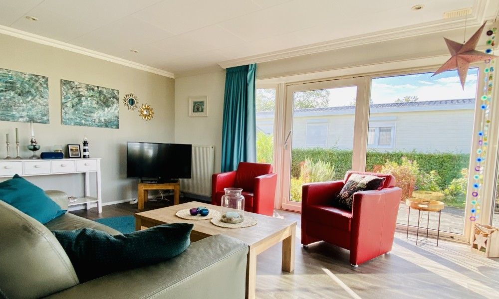 Gezellige woonkamer in Casa Mari, een chalet in Breskens, Zeeuws-Vlaanderen, met veel natuurlijk licht en comfortabel interieur.