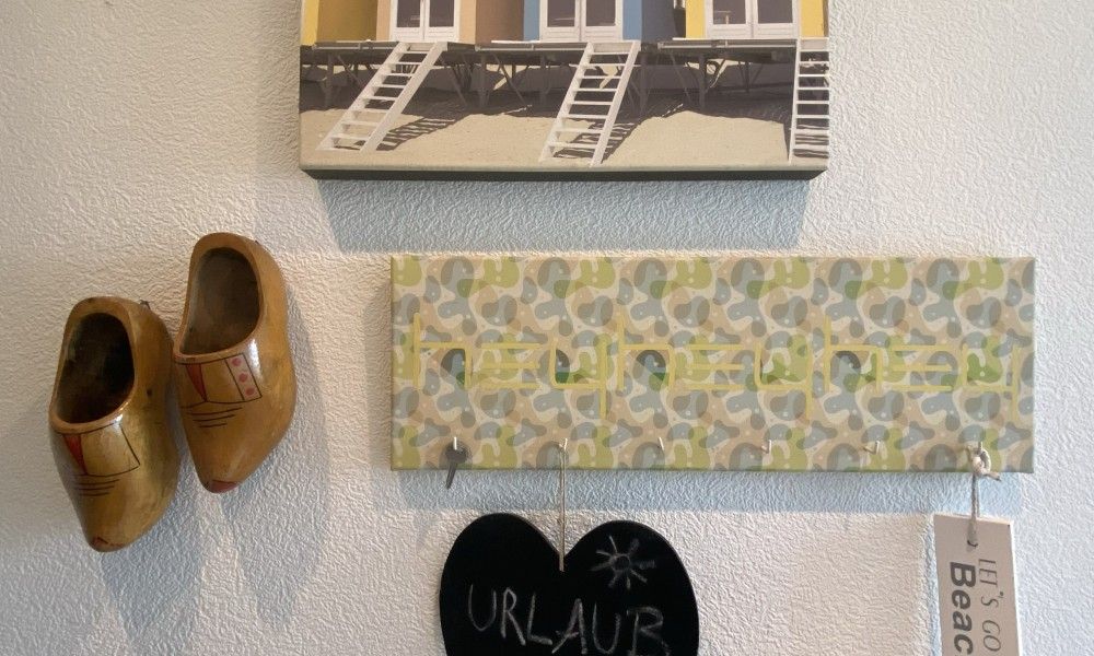 Authentieke decoratie in Casa Mari, chalet in Breskens, Zeeuws-Vlaanderen, met klompen en strandkunst voor een lokale sfeer.